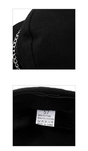 Detail of wool fabric with silver chain trim and inner care label on black beret hat
