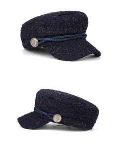 Detail of navy blue tweed military cap with gold buttons and braided rope decoration