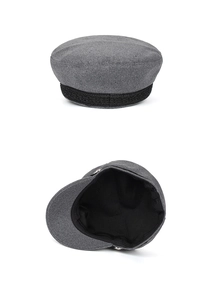 Detail view of grey wool newsboy cap featuring black woven ribbon trim and soft inner lining
