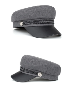 Detail view of gray newsboy cap featuring textured wool blend and black cord decoration