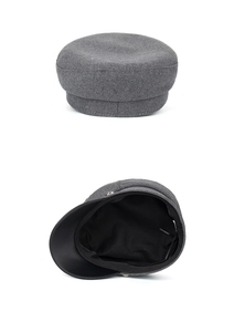 Detailed view of grey wool newsboy cap with black faux leather brim and inner lining