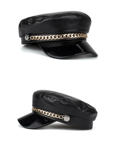 Detailed close-up of black PU leather baker boy hat with chunky gold metal chain detail