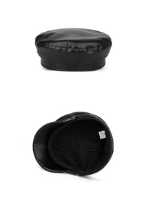 Detail view of the black PU leather baker boy hat interior with washing label and lining