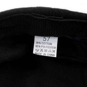 Detail view of the black beret size label with silver chain accent and 57 size marker