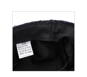 Detailed interior of the tweed beret showing the size 58 and material composition tag