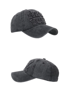 Dettaglio del cappellino da baseball nero lavato con ricamo New York e texture invecchiata