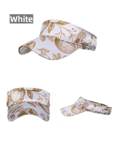 Detail view of white open-top sun hat with golden floral print and twill texture