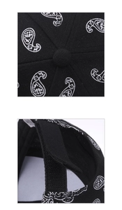 Detail of paisley print baseball cap showing top button and adjustable hook and loop closure