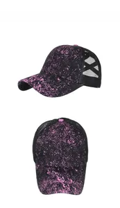 Detail view of black and purple glitter ponytail baseball cap with criss-cross mesh back