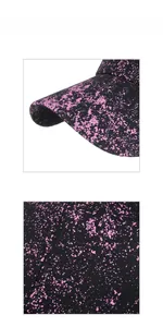 Close-up of black baseball cap with vibrant pink paint splatter and detailed stitching