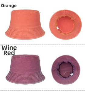 Detail view of washed canvas bucket hats in orange and burgundy showing stitching and inner lining