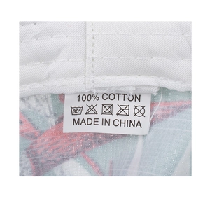 Detail view of the 100% cotton material care label on printed sun protection bucket hat