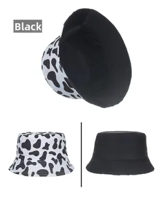 Close-up detail of double-sided bucket hat featuring black cow print and solid black fabric