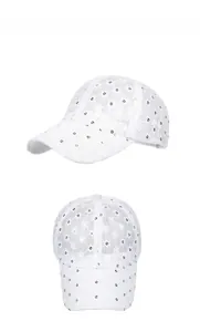 Detailed view of white lace baseball cap featuring shimmering sequins and mesh patterns