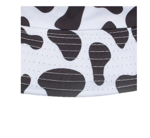 Close-up of cow print bucket hat featuring double-stitched seams and cotton fabric texture
