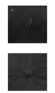 Detail view of the crown seams and embroidered eyelets on this black cotton baseball cap