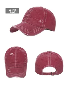 Detail view of washed burgundy baseball cap showing distressed holes and metal buckle
