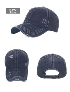 Detail view of navy blue washed denim baseball cap with distressed rips and contrast stitching
