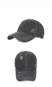 Detail of washed denim baseball cap featuring vintage distressed holes and contrast stitching
