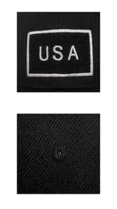 Detail of USA embroidery patch and stitched eyelet on a black cotton baseball cap