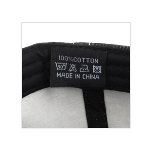 Close-up of the washing label showing 100% cotton material and care symbols for the cap