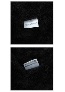 Detail shot of 100% acrylic knitted fabric with soft fleece lining and care label info
