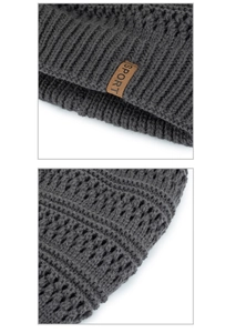 Macro detail of dark grey chunky knit beanie with premium thick texture and sport leather tag