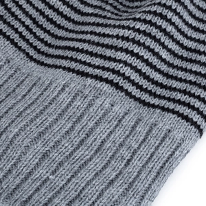 Gros plan d'un bonnet en maille acrylique à rayures grises et noires avec bords côtelés