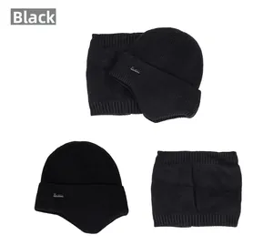 Detail view of black knit winter set featuring earflap beanie and neck gaiter for skiing