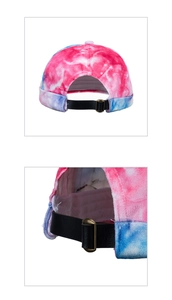 Detail of adjustable black leather strap and bronze metal buckle on tie-dye beanie cap