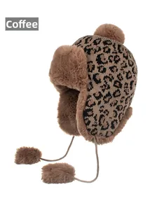 Detailed view of coffee leopard print winter hat with faux fur lining and pom poms