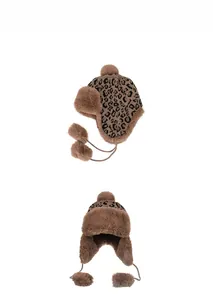 Detail of leopard print knit trapper hat with warm faux fur lining and plush pom-poms