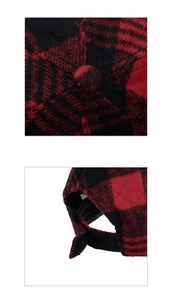 Detail of adjustable hook and loop fastener and crown button on red buffalo plaid cap