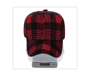 Close-up of red and black buffalo plaid baseball cap weighing 82.9g on a scale