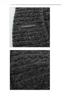 Detailed knit texture of chenille twist scarf with a gold fashion emblem tag