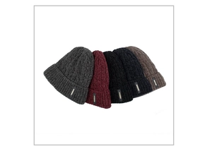 Close-up of five knitted chenille beanies in various colors with thick cable stitch details