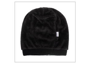 Detail of black faux fur knit beanie showing 100% acrylic material label and rib cuff