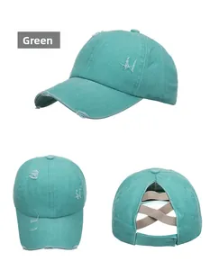 Détail de la casquette verte délavée avec trous usés et élastique croisé pour queue de cheval