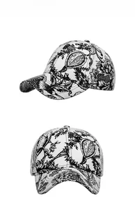 Detail view showing ink wash floral print on a white cotton baseball cap for sun protection