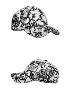 Detailed close-up of white canvas baseball cap with black Toile de Jouy floral print