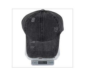 Détail de la casquette de baseball en denim délavé de 78,5g posée sur une balance