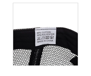 Gros plan de l'étiquette de lavage sur un chapeau en maille noire montrant la matière