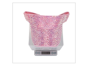 Pink sun visor hat with colorful rhinestones on a scale showing 118.9g weight