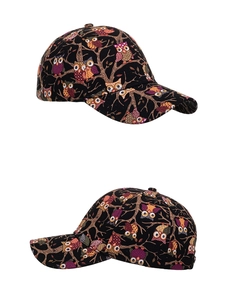 Detail view of cotton baseball cap featuring colorful cartoon owl prints on black fabric