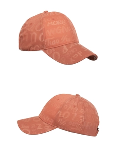 Detailed macro view of the brick red baseball cap with textured letter graffiti embossing