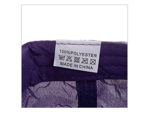 Detailed care label showing 100% polyester composition and washing instructions on purple cap