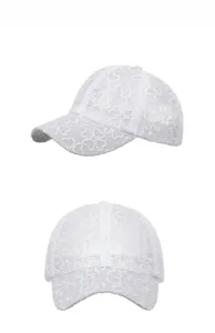 Detail view of white lace embroidery on outdoor baseball cap with heart flower patterns