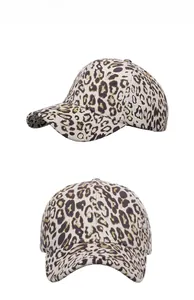 Detail of trendy leopard print baseball cap with metallic gold speckles on white surface