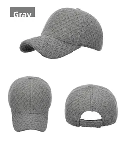 Detail view of grey knitted baseball cap showing textured diamond pattern and strap