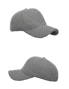 Close-up of grey knitted baseball cap showing diamond grid texture and curved brim